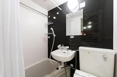 a bathroom with a sink and a toilet and a mirror at JASPER Waseda in Tokyo
