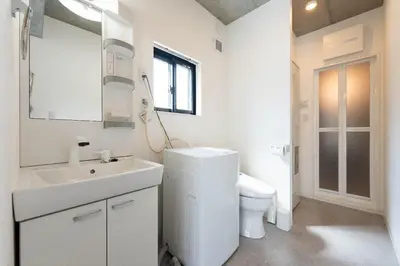 a white bathroom with a toilet and a sink at JASPER Waseda in Tokyo