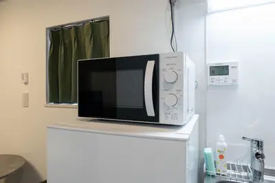 a microwave sitting on top of a refrigerator at JASPER Waseda in Tokyo