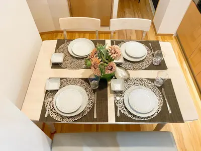 a dining room table with plates and flowers on it at Tokyo Louis House in Ueno area close to JR Yamanote Line & Metro Ginza Line walk to Ueno Park and Ameyoko in Tokyo