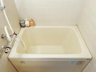 a white bath tub in a white tiled bathroom at Tokyo Louis House in Ueno area close to JR Yamanote Line & Metro Ginza Line walk to Ueno Park and Ameyoko in Tokyo