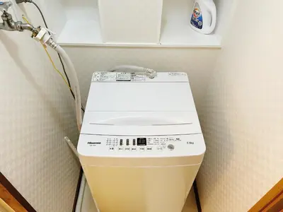 a washing machine in a corner of a room at Tokyo Louis House in Ueno area close to JR Yamanote Line & Metro Ginza Line walk to Ueno Park and Ameyoko in Tokyo
