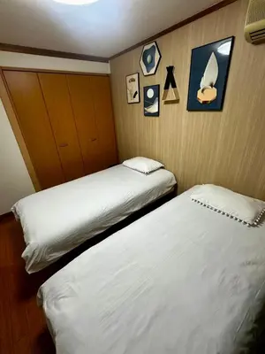 two beds in a hotel room with pictures on the wall at Yama house AD0234 in Tokyo