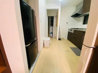 a kitchen with a black refrigerator and a wooden floor at Yama house AD0234 in Tokyo