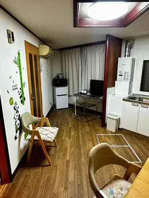 a living room with a kitchen and a table and chairs at Yama house AD0234 in Tokyo