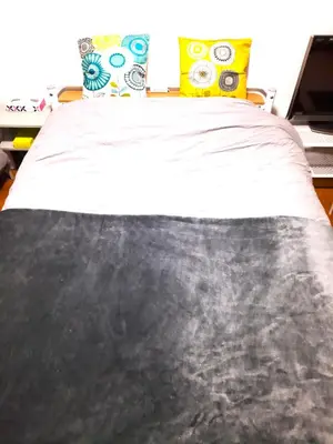 a bedroom with a bed with a black and white blanket at Shinjuku Harusame Apartment -Twin room- in Tokyo