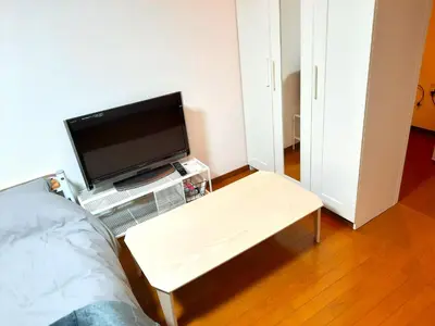a bedroom with a tv and a coffee table at Shinjuku Harusame Apartment -Twin room- in Tokyo