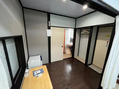 an empty room with a table and a bathroom at Lucky Hotel in Tokyo