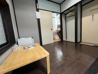 a room with a wooden table and a hallway at Lucky Hotel in Tokyo