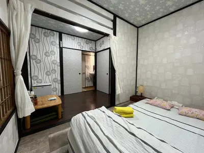 a bedroom with a bed and a table in it at Lucky Hotel in Tokyo