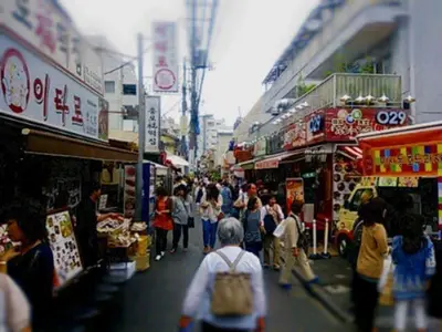 a group of people walking through a street market at Lucky Hotel in Tokyo