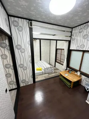an empty room with a bed and a table at Lucky Hotel in Tokyo