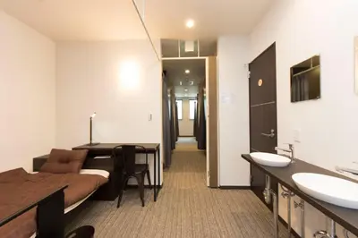 a room with a bed and a bathroom with a sink at Ryoma Ikebukuro male only -Guest House - Vacation STAY 14547v in Tokyo