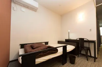 a bedroom with a bed and a desk and a table at Ryoma Ikebukuro male only -Guest House - Vacation STAY 14547v in Tokyo
