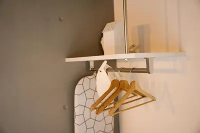 a closet with a rack with a white shirt and a mirror at FL Residence Shinjuku I in Tokyo
