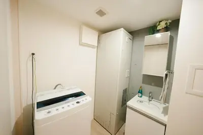 a small white kitchen with a sink and a dishwasher at FL Residence Shinjuku I in Tokyo