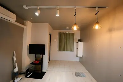 an empty room with a television and lights on the ceiling at FL Residence Shinjuku I in Tokyo