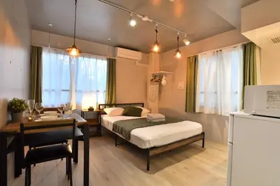 a room with two beds and a table and a desk at FL Residence Shinjuku I in Tokyo