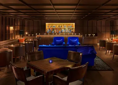 a restaurant with a blue couch and tables and chairs at The Tokyo EDITION, Ginza in Tokyo