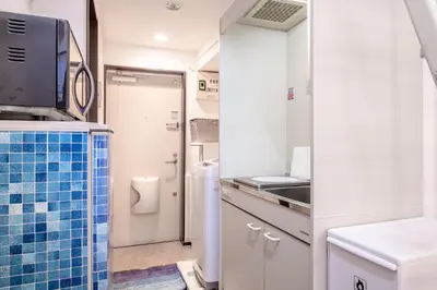 a small kitchen with a blue tiled counter top at \u30f4\u30a3\u30f3\u30c6\u30fc\u30b8\u30c7\u30b6\u30a4\u30f3\u795e\u697d\u5742102 in Tokyo