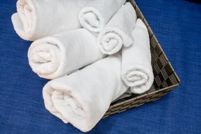 a basket filled with white towels on a bed at \u30f4\u30a3\u30f3\u30c6\u30fc\u30b8\u30c7\u30b6\u30a4\u30f3\u795e\u697d\u5742102 in Tokyo