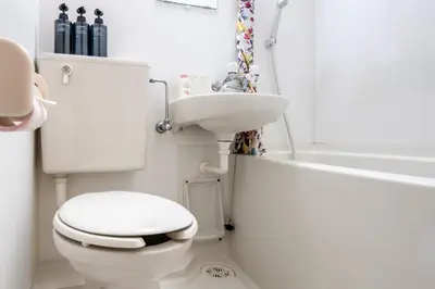 a white bathroom with a toilet and a sink at \u30f4\u30a3\u30f3\u30c6\u30fc\u30b8\u30c7\u30b6\u30a4\u30f3\u795e\u697d\u5742102 in Tokyo