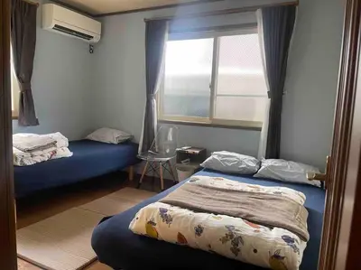 a bedroom with two beds and a window at M&Ks house in Tokyo
