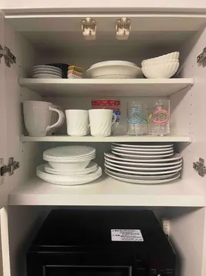 a cabinet filled with plates and bowls and dishes at M&Ks house in Tokyo