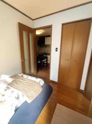a bedroom with a bed and a wooden door at M&Ks house in Tokyo