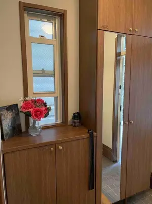 a room with a window and a vase of flowers on a cabinet at M&Ks house in Tokyo