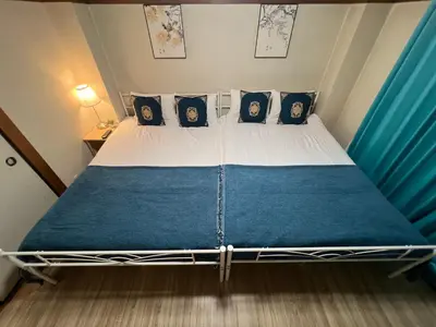a bedroom with a bed with blue and white sheets at LifeHouse \u62bc\u4e0a\u99c5\u304b\u3089\u5f92\u6b695\u5206 \u30b9\u30ab\u30a4\u30c4\u30ea\u4e00\u307e\u3067\u5f92\u6b659\u5206 \u6700\u59276\u4ebaok \u6709\u514d\u8d39WiFi in Tokyo