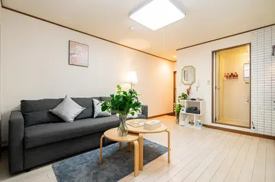 a living room with a couch and a table at LifeHouse \u62bc\u4e0a\u99c5\u304b\u3089\u5f92\u6b695\u5206 \u30b9\u30ab\u30a4\u30c4\u30ea\u4e00\u307e\u3067\u5f92\u6b659\u5206 \u6700\u59276\u4ebaok \u6709\u514d\u8d39WiFi in Tokyo