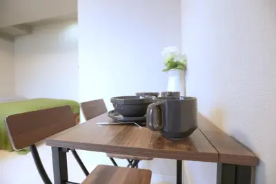 a wooden table with a bowl and a vase on it at Shinjuku Ryokan Retreat丶Local Tokyo Experience & Short Trips Hub丶walk to Higahsi Shinjuku station YEoL in Tokyo