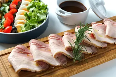 a wooden cutting board with ham and vegetables and a salad at Premier hotel -CABIN PRESIDENT- Tokyo in Tokyo