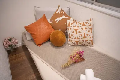 a couch with pillows and flowers on it at \u94f6\u5ea7\u5408\u4e4b\u5c4b \u7b51\u5730\u5e02\u573a\u5730\u94c1\u4e09\u5206\u949f \u94f6\u5ea7\u5f92\u6b65\u5341\u5206\u949f in Tokyo