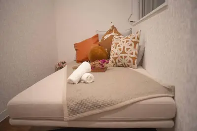 a bed with pillows and a stuffed animal on it at \u94f6\u5ea7\u5408\u4e4b\u5c4b \u7b51\u5730\u5e02\u573a\u5730\u94c1\u4e09\u5206\u949f \u94f6\u5ea7\u5f92\u6b65\u5341\u5206\u949f in Tokyo