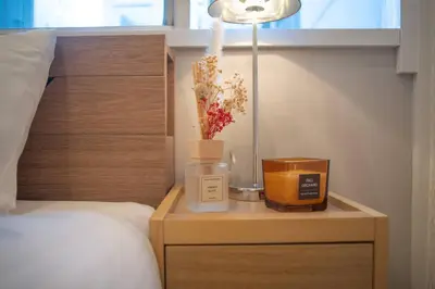 a bedroom with a bed and a night stand with a lamp at \u94f6\u5ea7\u5408\u4e4b\u5c4b \u7b51\u5730\u5e02\u573a\u5730\u94c1\u4e09\u5206\u949f \u94f6\u5ea7\u5f92\u6b65\u5341\u5206\u949f in Tokyo