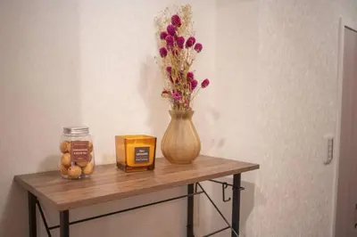 a wooden table with a vase with flowers and a candle at \u94f6\u5ea7\u5408\u4e4b\u5c4b \u7b51\u5730\u5e02\u573a\u5730\u94c1\u4e09\u5206\u949f \u94f6\u5ea7\u5f92\u6b65\u5341\u5206\u949f in Tokyo