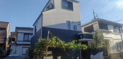 a tall building with a black wall and some buildings at JINGHOUSE高砂（無料駐車場）一戸建て 上野/浅草/银座/天空树 in Tokyo