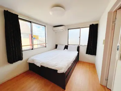 a small bedroom with a bed and two windows at JINGHOUSE高砂（無料駐車場）一戸建て 上野/浅草/银座/天空树 in Tokyo