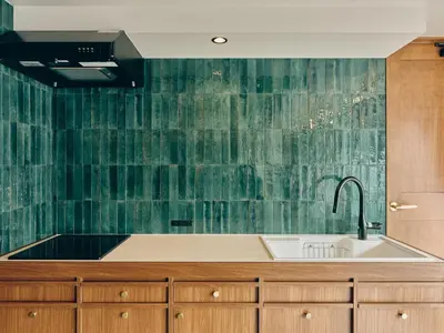 a kitchen with a sink and a green wall at illi Com Shimokitazawa in Tokyo