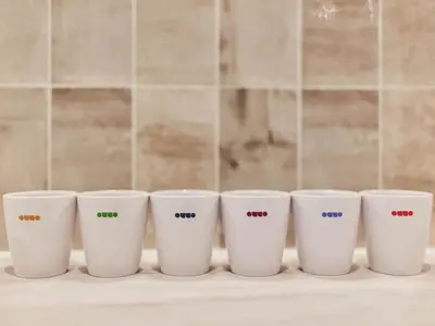a row of four coffee cups sitting on a counter at illi Com Shimokitazawa in Tokyo