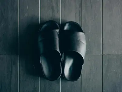 a pair of black shoes sitting on a tile floor at illi Com Shimokitazawa in Tokyo