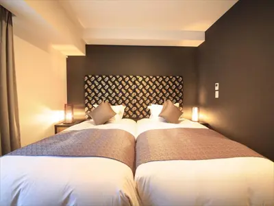 a bedroom with two beds in a room at Centurion Hotel Ikebukuro Station in Tokyo