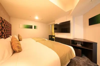 a bedroom with a large white bed and a television at Centurion Hotel Ikebukuro Station in Tokyo
