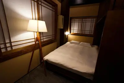 a small bedroom with a bed and a lamp at HOTEL Lee in Tokyo