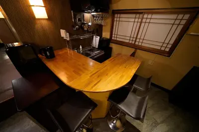 a kitchen with a wooden table and some chairs at HOTEL Lee in Tokyo