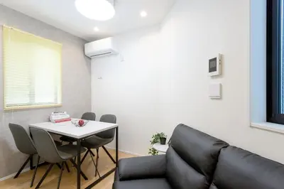 a living room with a table and a couch at Shinjuku City House \u65b0\u5bbf\u30b7\u30c6\u30a3\u30cf\u30a6\u30b9 in Tokyo