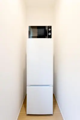a microwave sitting on top of a white refrigerator at Shinjuku City House \u65b0\u5bbf\u30b7\u30c6\u30a3\u30cf\u30a6\u30b9 in Tokyo
