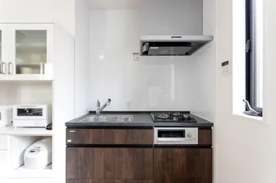 a kitchen with a sink and a stove top oven at Shinjuku City House \u65b0\u5bbf\u30b7\u30c6\u30a3\u30cf\u30a6\u30b9 in Tokyo